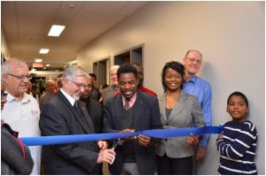 Brother F. Louis-Paul Lavallée, FSC, Visitor of the Francophone Canada district, cuts the ribbon with the help of Mr. Frantz Benjamin, city councilor of the Saint Michel district, Montréal.